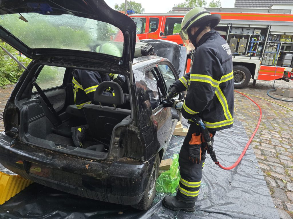 Ein Mitglied der Freiwilligen Feuerwehr bei einer Übung an einem Unfallwagen